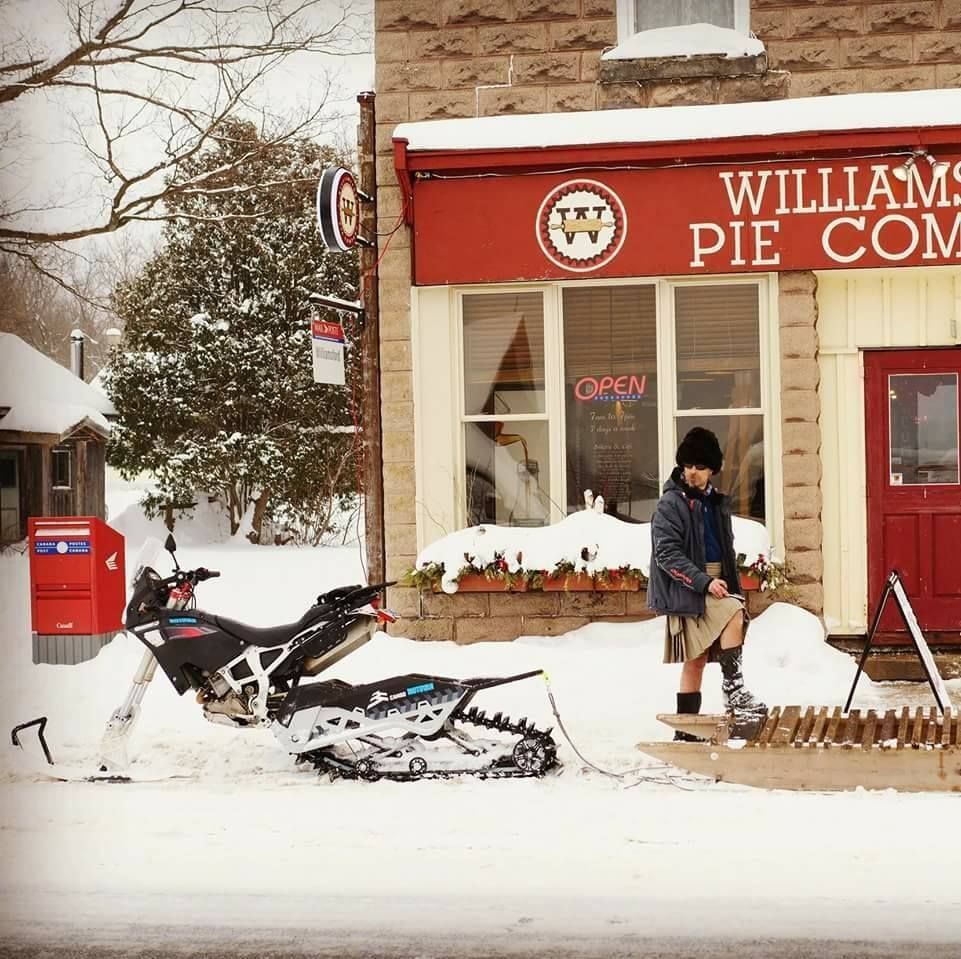 Picking up pie with his snow bike, sled, and winter kilt.